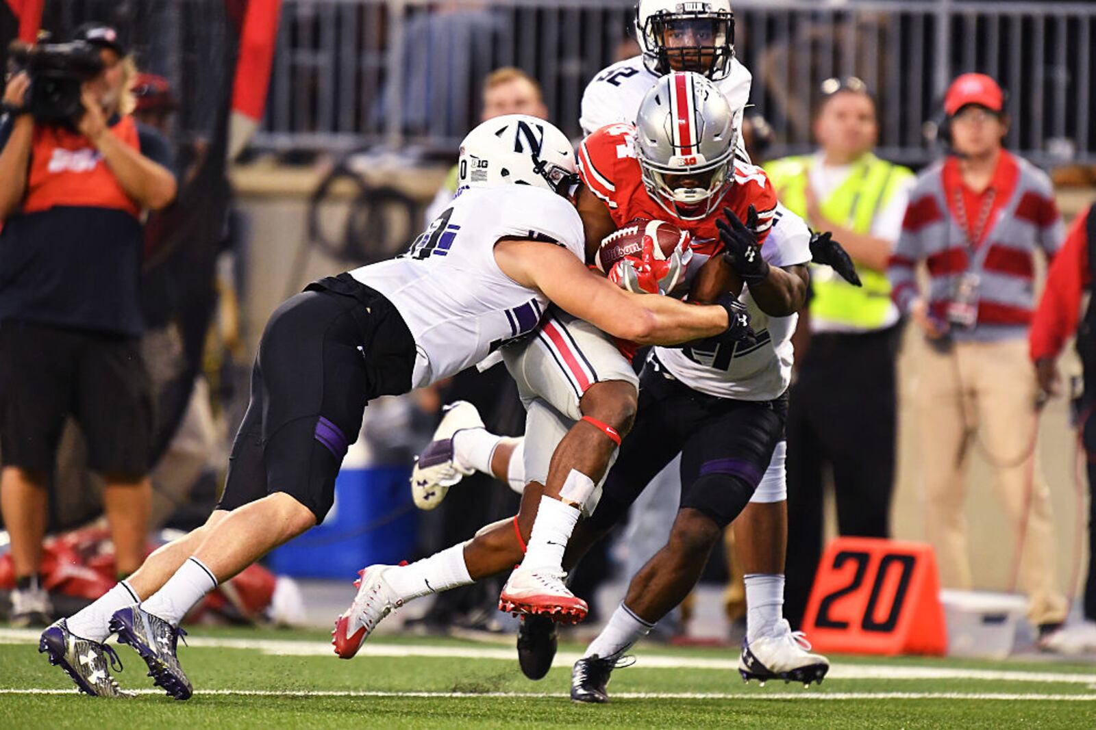 COLUMBUS, OH - OCTOBER 29:  K.J. Hill #14 of the Ohio State Buckeyes is hauled down by Brett Walsh #10 of the Northwestern Wildcats and Daniel Kubiuk #17 of the Northwestern Wildcats after a 34-yard pass reception in the third quarter to set up a touchdown at Ohio Stadium on October 29, 2016 in Columbus, Ohio. Ohio State defeated Northwestern 24-20.  (Photo by Jamie Sabau/Getty Images)