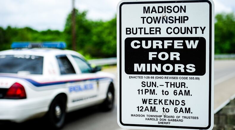 A sign displaying curfew times for minors is on display along Ohio 122 entering Madison Twp. NICK GRAHAM/STAFF