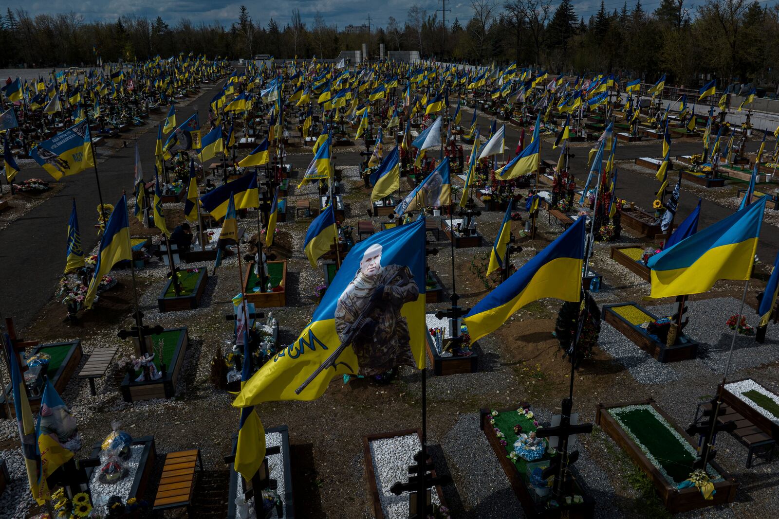 National flags wave on graves of Ukrainian soldiers killed since a beginning of Russian invasion, at the military cemetery in Kryvyi Rih, Ukraine, Wednesday April 9, 2025. (AP Photo/Evgeniy Maloletka)