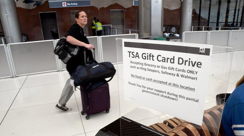A traveler walks past a gift card donation box for Transportation Security Administration officers at Denver International Airport on Friday, March 20, 2026. (AP Photo/Thomas Peipert)