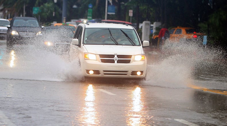 Cars move through the flooded roads caused by Tropical Storm Nicole in Miami Beach, Florida, Sept. 29, 2010. Hazard lights worsen the danger of driving in a downpour, safety experts say. (David Santiago/Miami Herald/TNS)