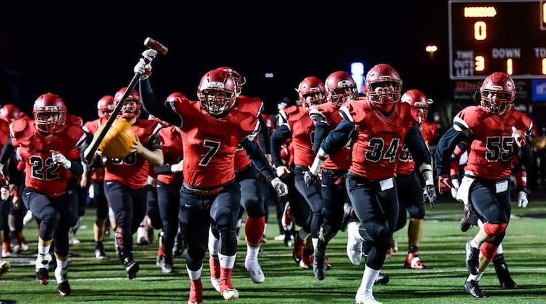 Mason Whiteman (7), Evan Crim (34), Levi Wilson (55) and Drew Price (22) lead Madison High School’s football team onto the field at Lakota East last Friday night before their 35-27 victory over Cincinnati Hills Christian Academy in a Division V, Region 20 semifinal. NICK GRAHAM/STAFF