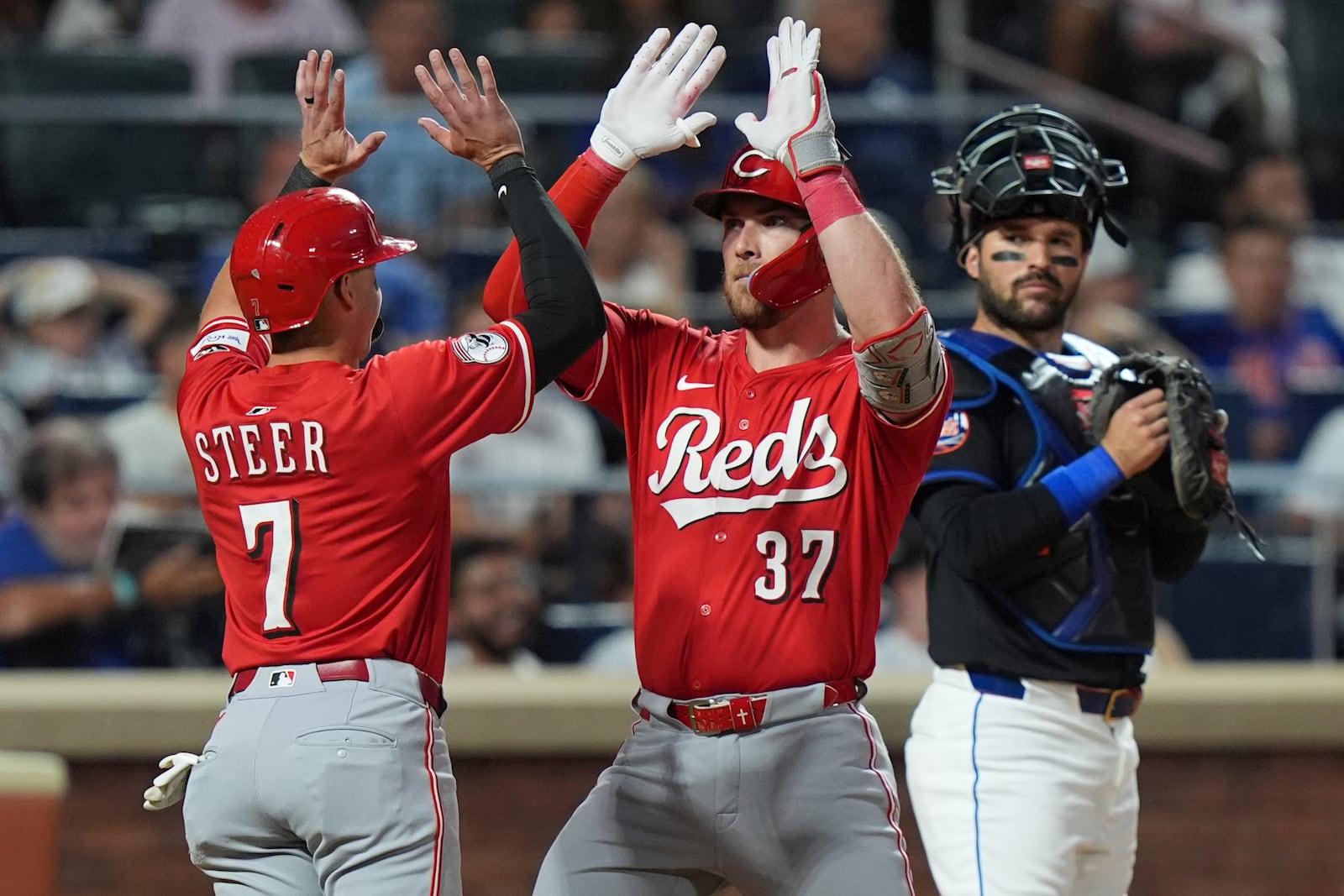 New York Mets catcher Luis Torrens watches as Cincinnati Reds' Tyler Stephenson (37) celebrates with Spencer Steer (7) after they score on two-run home run by Stephenson during the sixth inning of a baseball game Friday, July 18, 2025, in New York. (AP Photo/Frank Franklin II)