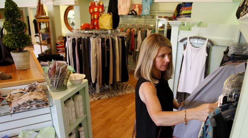 Lori Brown of Oakwood looks through the racks Tuesday at Get Dressed!, a clothing store in Oakwood. Retail sales ticked up a slight 0.2 percent in June, disappointing some analysts who had predicted a more robust performance but offering a few glimmers of hope that cautious consumers were laying a foundation for a stronger economic recovery.