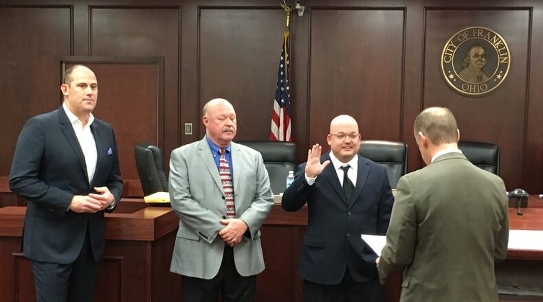 Matt Wilcher raises his hand as he is sworn-in as a member of Franklin City Council by Franklin Municipal Court Judge Ron Ruppert on Wednesday at the Franklin City Building. Returning Councilmen Michael Aldridge, left, and Denny Centers await their turn to take their oaths of office. ED RICHTER/STAFF
