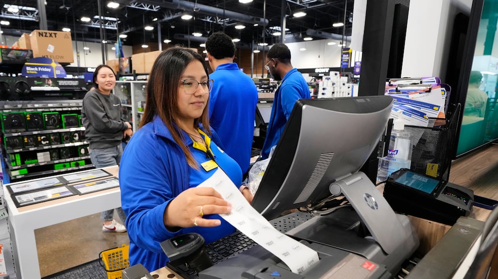 Abril Renteria, an Apple certified advisor, helps a customer check out after their purchase at a Best Buy store, Wednesday, Nov. 26, 2025, in Dallas. (AP Photo/Tony Gutierrez)