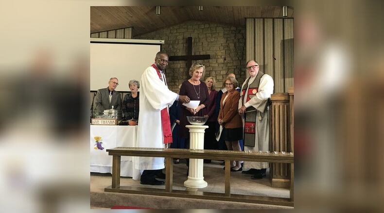 Pam Johnson, chairperson of Christ Church’s administrative team, lights a copy of the church’s mortgage, being held by Pastor Wynston Dixon, during a recent church service. SUBMITTED PHOTO