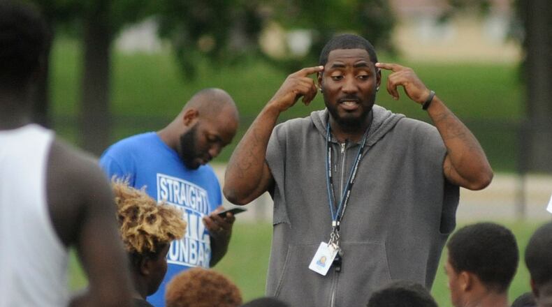 Dunbar head football coach Darran Powell addresses the Wolverines during practice last season. MARC PENDLETON / STAFF