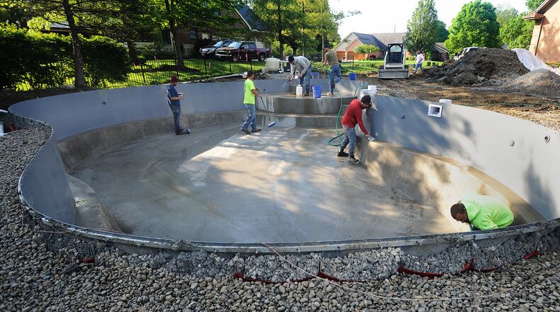 A crew from Buckeye Pools works on installing a new pool Thursday, May 20, 2021. Pool businesses are still seeing high demand. MARSHALL GORBY\STAFF