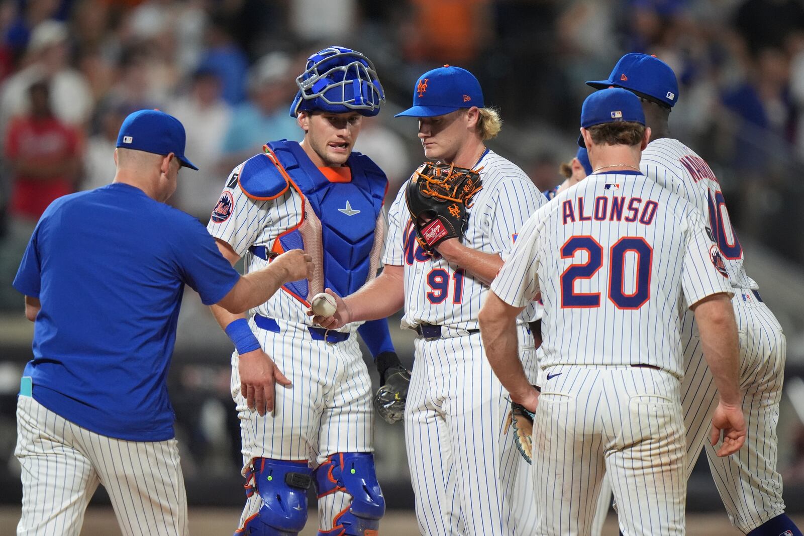 New York Mets pitcher Jonathan Pintaro, center, hands the ball to manager Carlos Mendoza as he leaves during the ninth inning of a baseball game against the Atlanta Braves Wednesday, June 25, 2025, in New York. (AP Photo/Frank Franklin II)