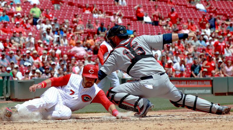 July 16 will be the city of Hamilton’s day to see the Cincinnati Reds at Great American Ball Park. Here, The Reds’ Eugenio Suarez, left, slides past the tag of Braves catcher A.J. Pierzynski and scores last season. DAVID JABLONSKI/STAFF