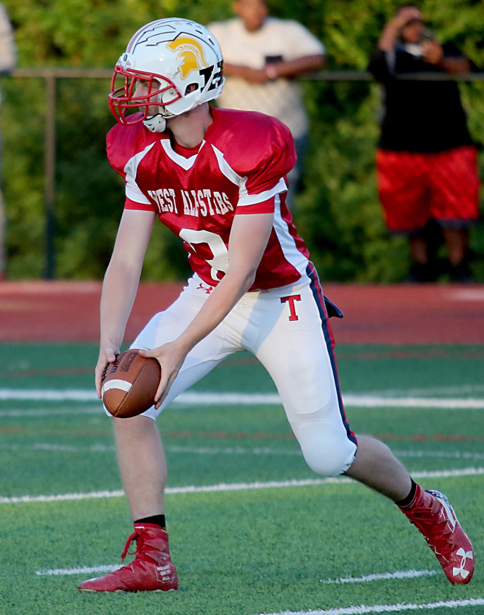 Talawanda quarterback Logan Kamphaus looks for a West teammate on a handoff Thursday night during the Southwestern Ohio Football Coaches Association Ron Woyan East-West All-Star Game at Kings. CONTRIBUTED PHOTO BY E.L. HUBBARD