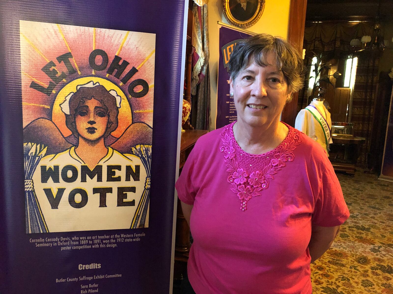 Kathy Creighton , executive director of the Butler County Historical Society, with a poster that urged Ohioans to give women the right to vote. That became reality on Aug. 18, 1920. Mike Rutledge/Staff