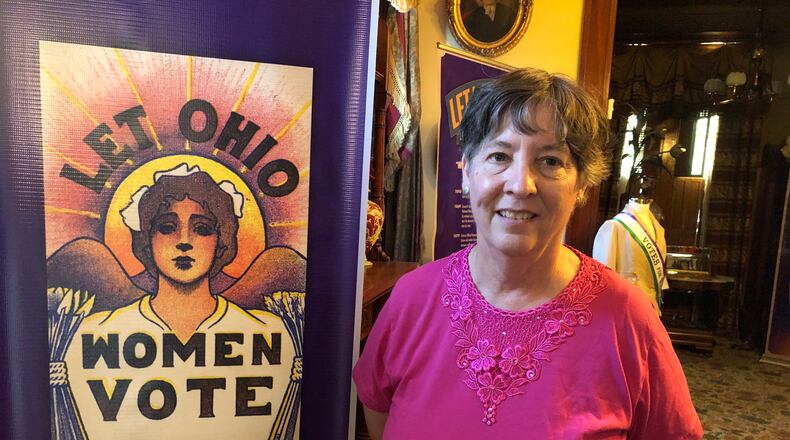 Kathy Creighton , executive director of the Butler County Historical Society, with a poster that urged Ohioans to give women the right to vote. That became reality on Aug. 18, 1920. Mike Rutledge/Staff
