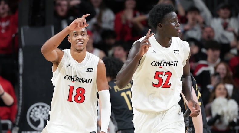 Cincinnati's Baba Miller, left, smiles after dunking during the second half of an NCAA college basketball game against Central Florida, Sunday, Feb. 8, 2026, in Cincinnati. (AP Photo/Kareem Elgazzar)