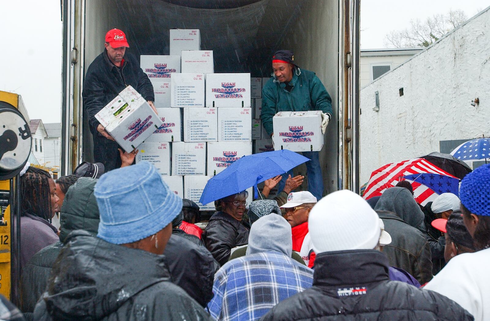 E.L. HUBBARD/JOURNALNEWS
Volunteers from Open Door Pantry on Front St. unload cases of green vegetables to those waiting Tuesday, 10/29/02.  The shipment came from Shared Harvest.