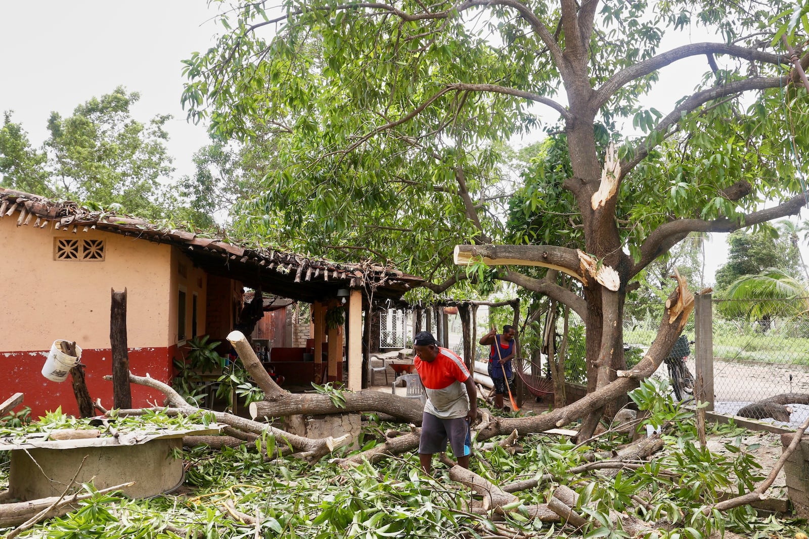 Residents remove debris after the passing of Hurricane Erick, near Charco Redondo, Oaxaca state, Mexico, Thursday, June 19, 2025. (AP Photo/Luis Alberto Cruz)