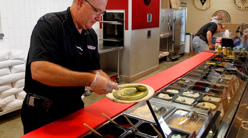 Ray Wiley, president and CEO of Rapid Fired Pizza, creates a pizza. The restuarant recently announced it will open inside at least one Kroger store. LISA POWELL / STAFF