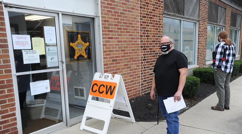 People line up outside the Greene County Sheriff's office Thursday morning to apply for a CCW permit. MARSHALL GORBY\STAFF