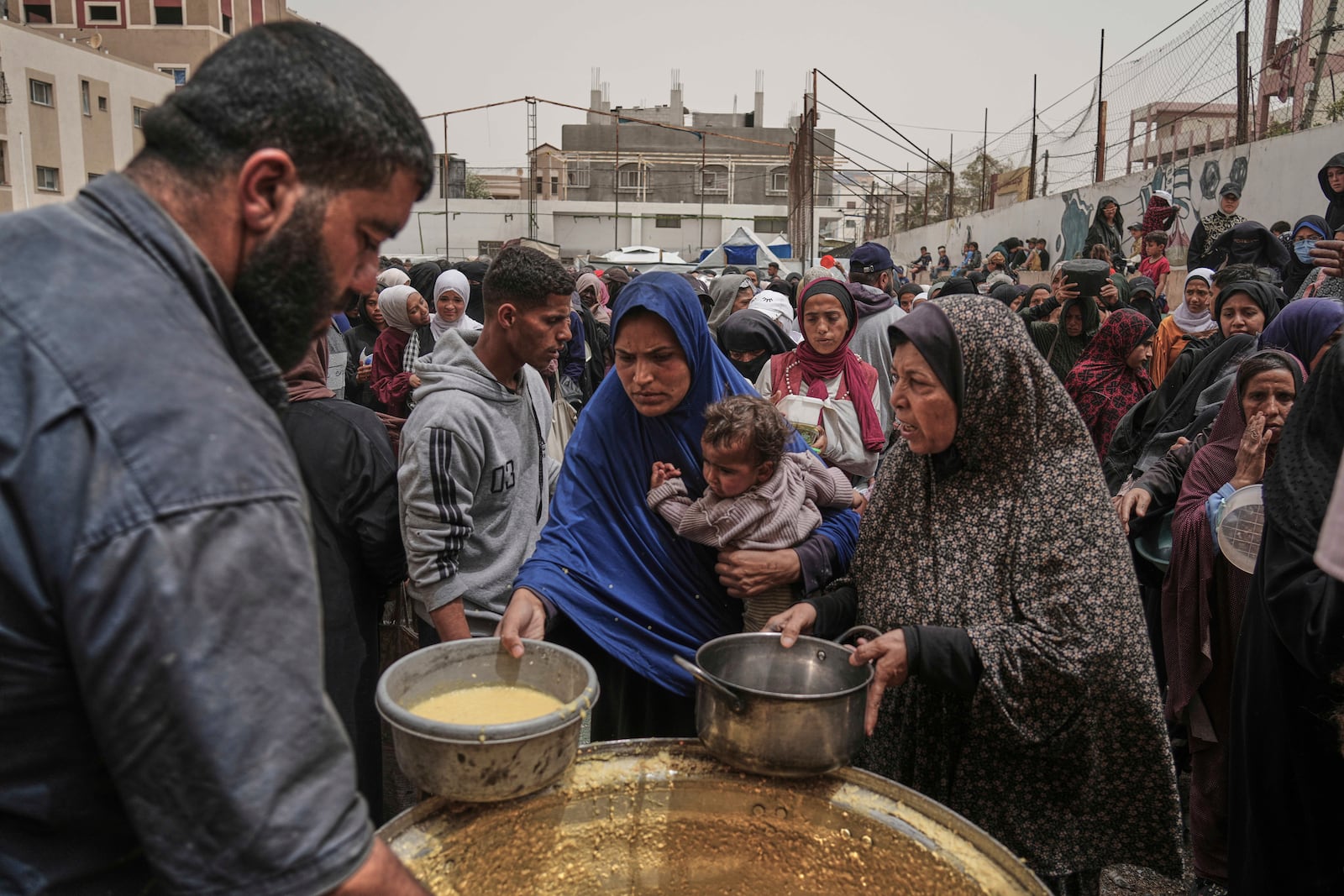 Palestinians receive donated food at a distribution center in Nuseirat, central Gaza Strip, Wednesday, April 30, 2025. (AP Photo/Abdel Kareem Hana)