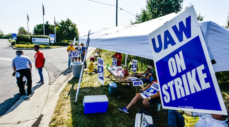 Employees stand near the entrance to the General Motors Service Parts Operations facility on Jacquemin Drive in West Chester Township as they join many United Auto Workers union employees around the country on strike against the automaker Monday, Sept. 16, 2019. NICK GRAHAM/STAFF