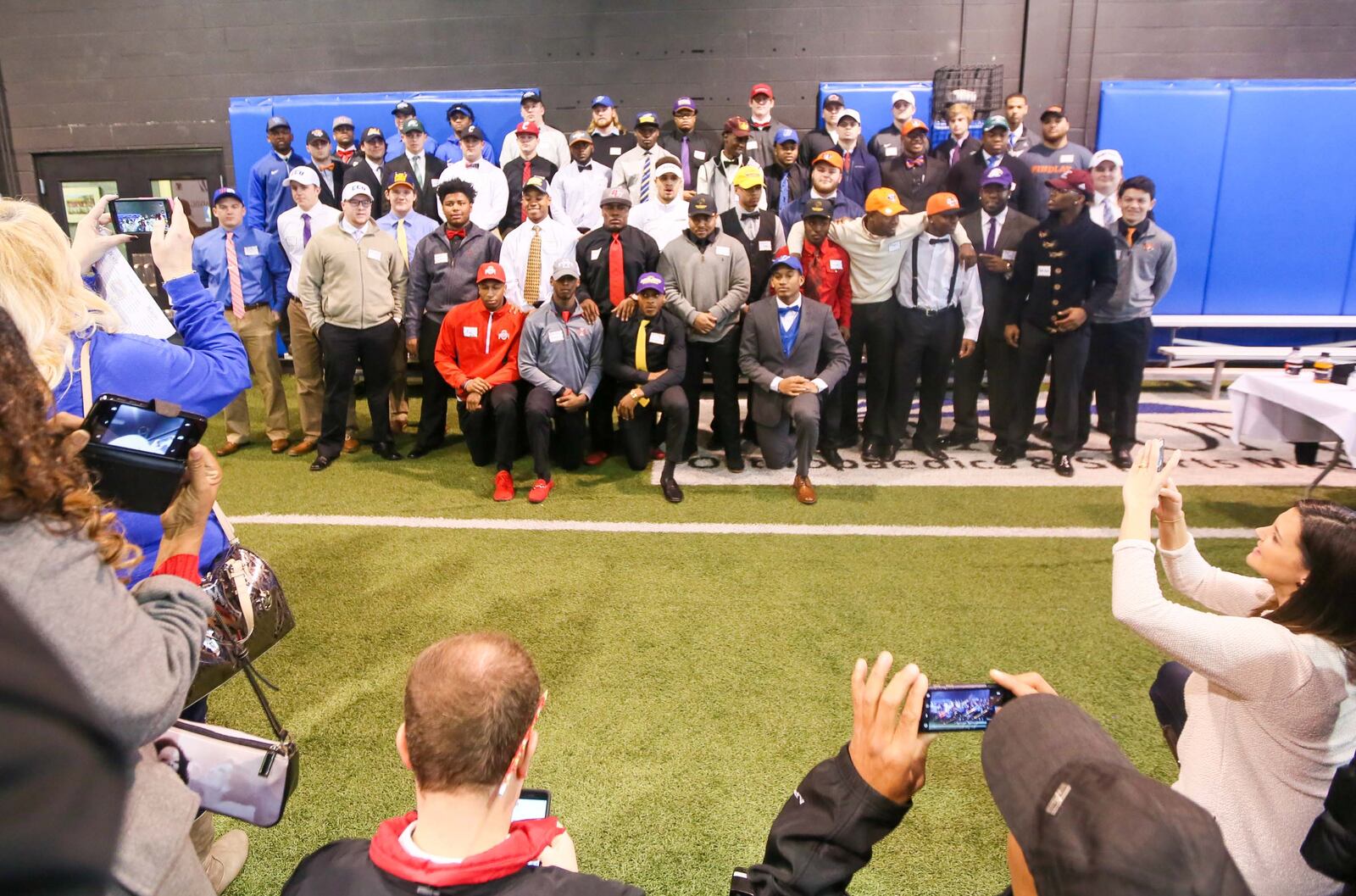 Student-athletes from the Class of 2017 pose for a photo during the National Signing Day event hosted by the Greater Miami Conference football coaches at Beacon Orthopaedics and Sports Medicine in Sharonville on Wednesday. GREG LYNCH/STAFF