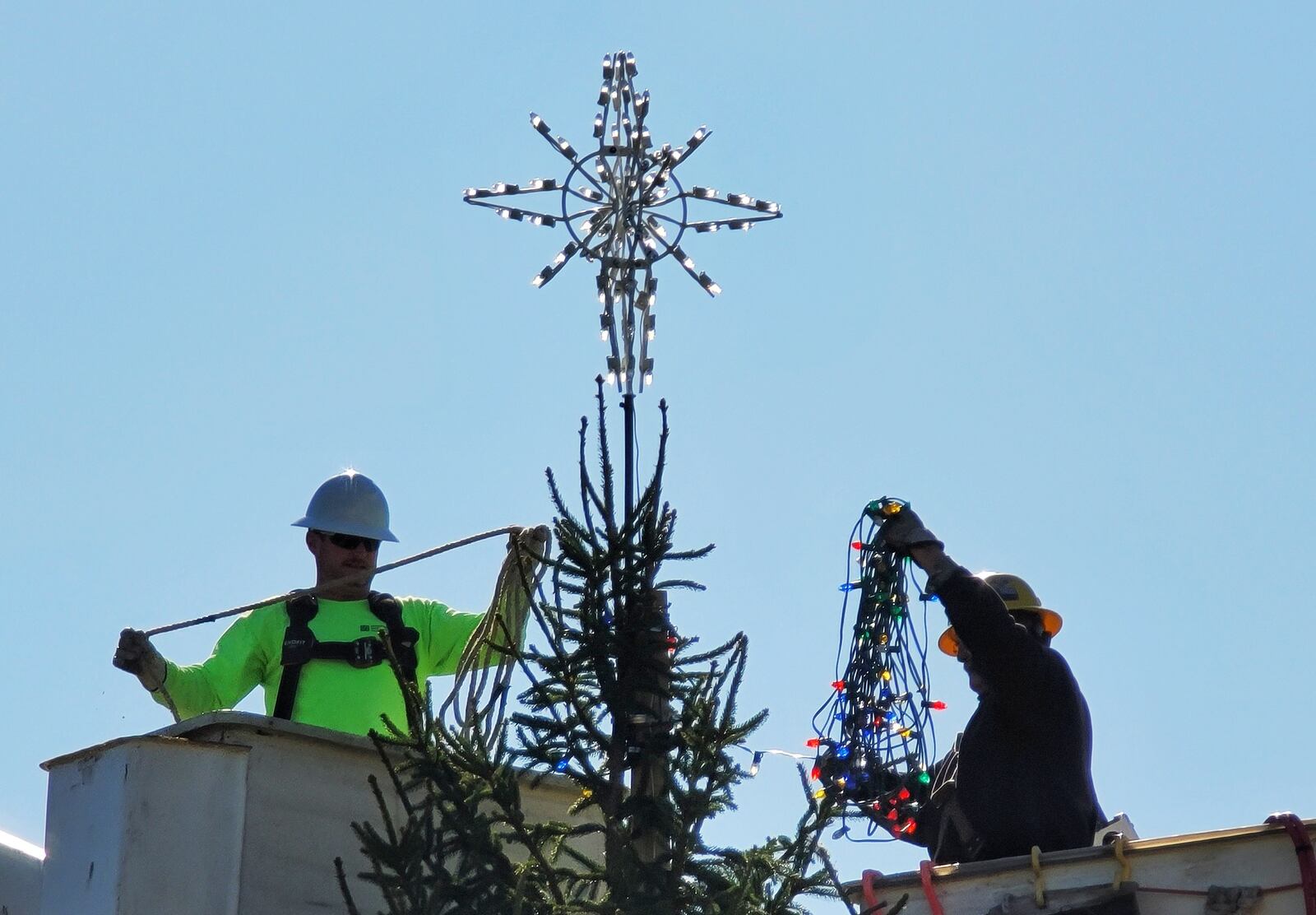 Hamilton city employees decorate a Christmas tree that was erected at Marcum Park. The tree was donated by Gary and Donna Trudel. NICK GRAHAM/STAFF