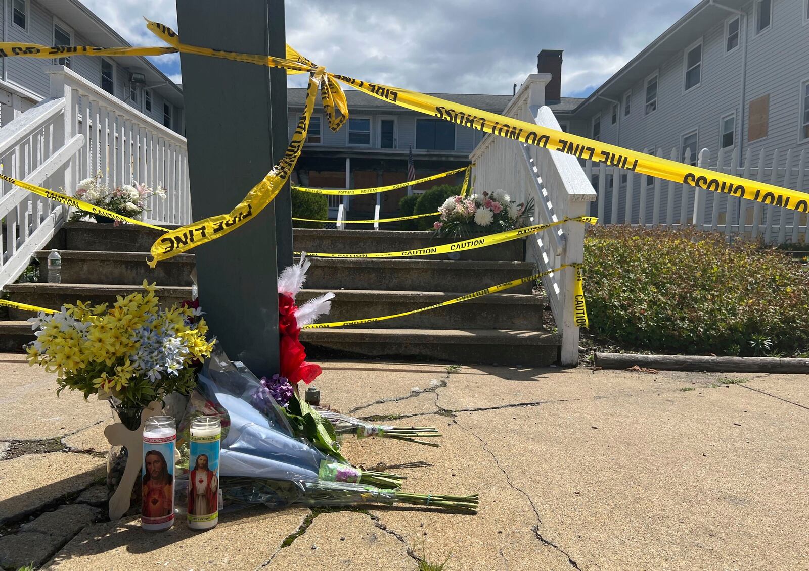 Flowers and candles sit in front of the Gabriel House assisted living home, where a fire on Sunday killed several people, Tuesday, July 15, 2025 in Fall River, Mass. (AP Photo/Kimberlee Kruesi)
