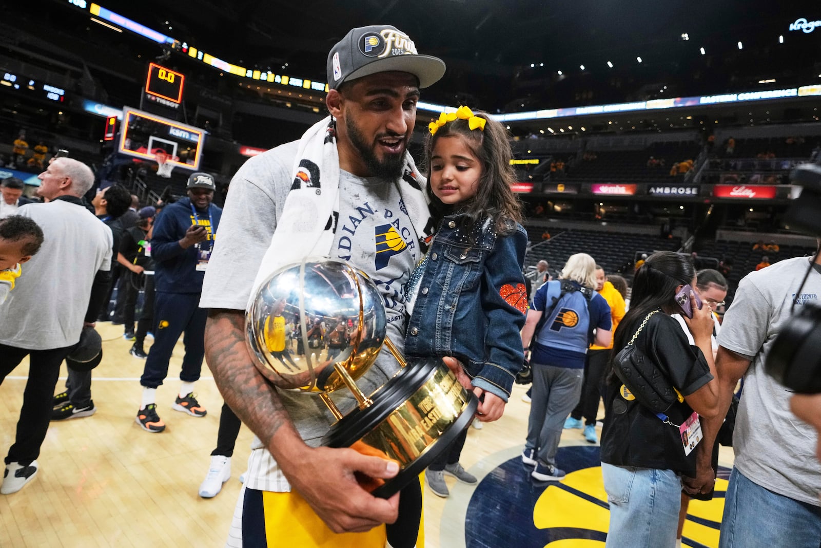 Indiana Pacers forward Obi Toppin holds his daughter, Remi Toppin, after the Pacers won Game 6 of the Eastern Conference finals of the NBA basketball playoffs against the New York Knicks in Indianapolis, Saturday, May 31, 2025. (AP Photo/Michael Conroy)