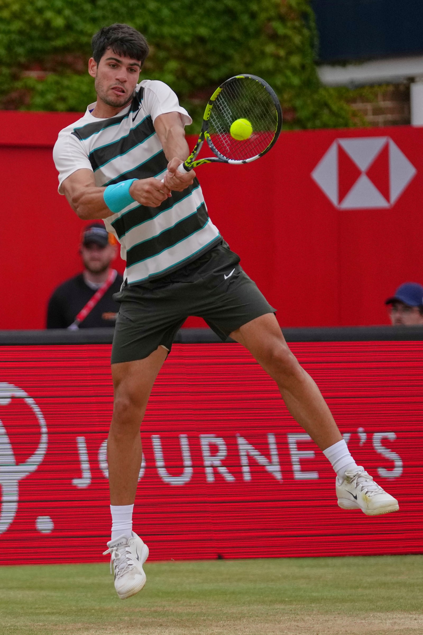 Carlos Alcaraz of Spain leaps as he plays a return to Jiri Lehecka of the Czech Republic, during the men's singles final of the Queens Club tennis championships in London, Sunday, June 22, 2025. (AP Photo/Joanna Chan)
