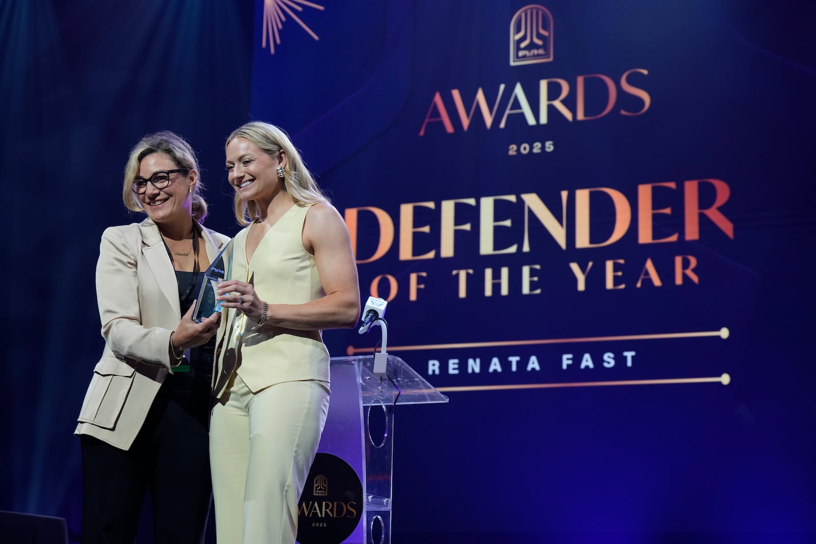 Cheryl Pounder, left, presents Toronto Sceptres' Renata Fast with the Defender of the Yearduring the PWHL women's hockey awards in Ottawa, Ontario,, Wednesday June 25, 2025. (Adrian Wyld/The Canadian Press via AP)