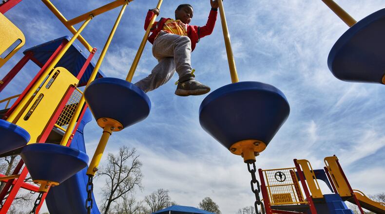Elisha Butler, 7, plays on the playground at Smith Park earlier this month. The city is asking residents to complete a parks survey in hopes of improving the park system. NICK GRAHAM / STAFF