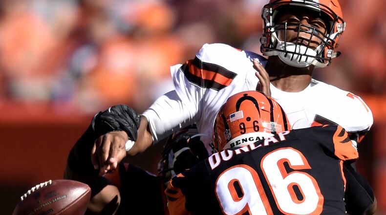 Cleveland Browns quarterback DeShone Kizer, top, loses control of the ball under pressure from Cincinnati Bengals defensive end Carlos Dunlap (96) in the second half of an NFL football game, Sunday, Oct. 1, 2017, in Cleveland. (AP Photo/David Richard)