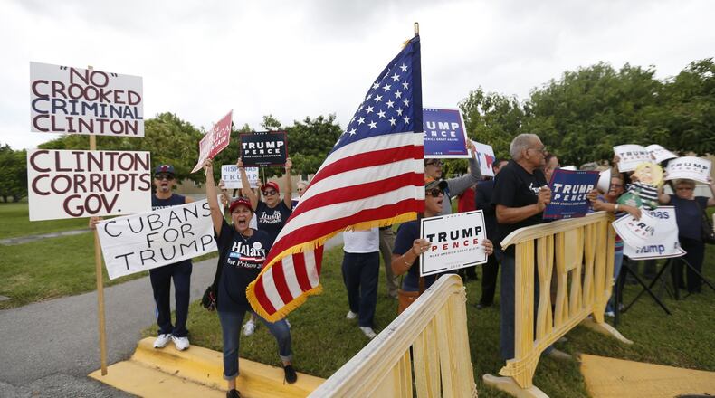 Supporters of Republican presidential candidate Donald Trump demonstrate outside a rally for Democratic presidential candidate Hillary Clinton, and former vice president Al Gore, Tuesday, Oct. 11, 2016, in Miami. During the event, Clinton will emphasizing her plans to develop more clean energy, reduce fossil fuel production and build more weather-resistant infrastructure. (AP Photo/Wilfredo Lee)