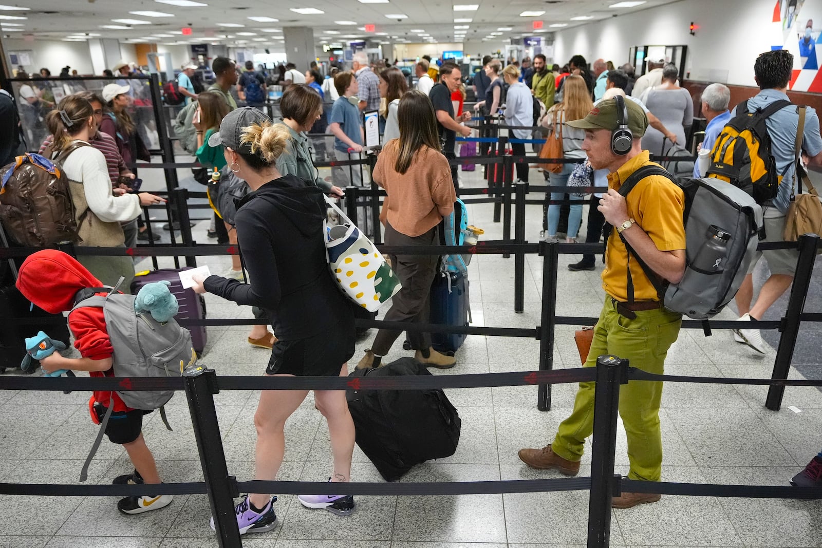 FILE - Travelers line up for security clearance at Hartsfield-Jackson Atlanta International Airport, June 28, 2024, in Atlanta. (AP Photo/Pablo Martinez Monsivais, File)