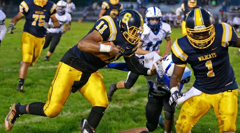 Springfield Leonard Taylor tries to avoid a tackle by Xenia’s Zahir Woodard as he carries the ball. Bill Lackey/Staff