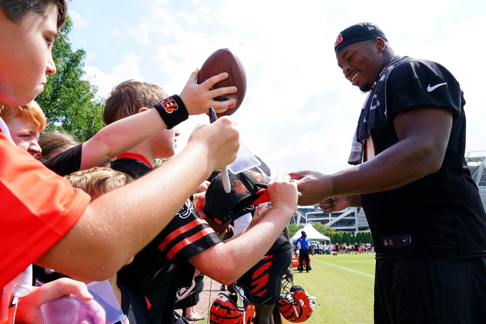 Cincinnati Bengals' Kris Jenkins Jr., right, signs autographs during practice at the team's NFL football training camp, Thursday, July 24, 2025, in Cincinnati. (AP Photo/Jeff Dean)