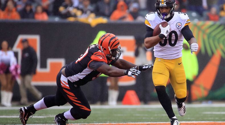 CINCINNATI, OH - OCTOBER 14: Geno Atkins #97 of the Cincinnati Bengals attempts to tackle James Conner #30 of the Pittsburgh Steelers during the third quarter at Paul Brown Stadium on October 14, 2018 in Cincinnati, Ohio. (Photo by Andy Lyons/Getty Images)