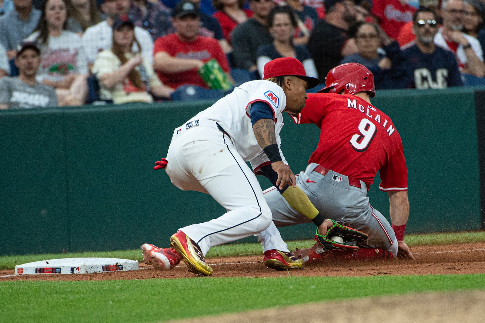 Cincinnati Reds' Matt McClain (9) is safe at third base as Cleveland Guardians' Jose Ramirez, left, is late with the tag during the eighth inning of a baseball game, Tuesday, June 10, 2025, in Cleveland. (AP Photo/Phil Long)