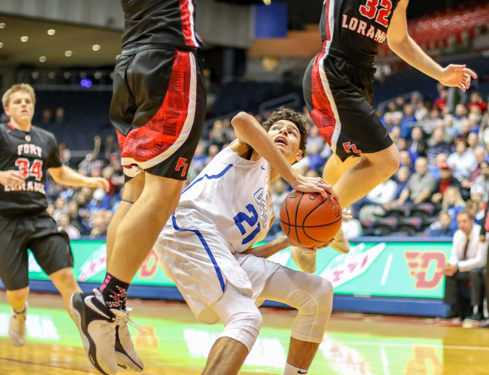 Cincinnati Christian’s Jalon Percy (21) is surrounded by leaping Fort Loramie Redskins on Friday night at the University of Dayton Arena. Fort Loramie won the Division IV district basketball final 49-41. CONTRIBUTED PHOTO BY MICHAEL COOPER