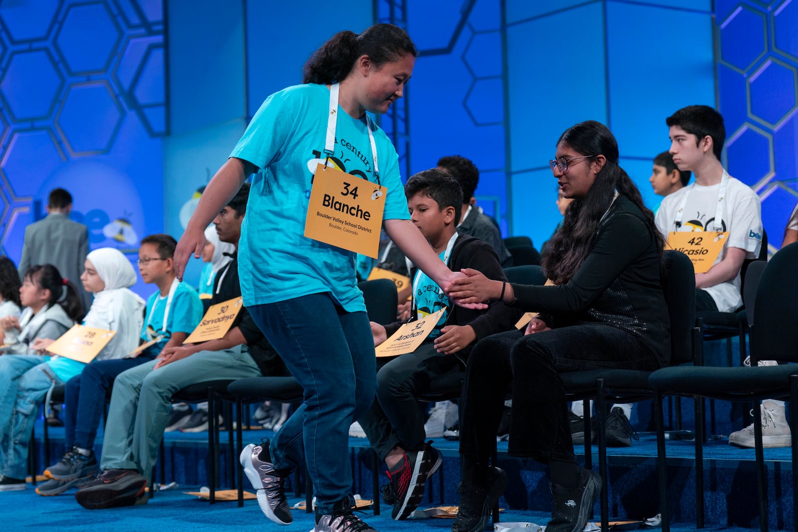 Blanche Yang Li, 14, of Boulder, Colo., high fives her friends after correctly spelling her word as she competes during the first preliminary round of the Scripps National Spelling Bee at the Gaylord National Resort & Convention Center, Tuesday, May 27, 2025, in Oxon Hill, Md. (AP Photo/Jose Luis Magana)g