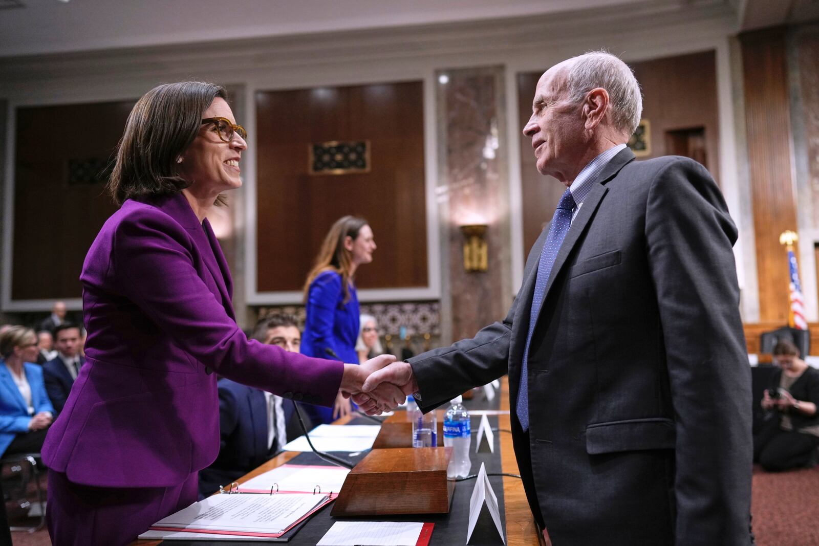 Former Justice Department attorney Liz Oyer, left, is welcomed by Sen. Peter Welch, D-Vt., to testify to House and Senate Judiciary Committee members at a hearing about the Justice Department, on Capitol Hill in Washington, Monday, April 7, 2025. (AP Photo/J. Scott Applewhite)