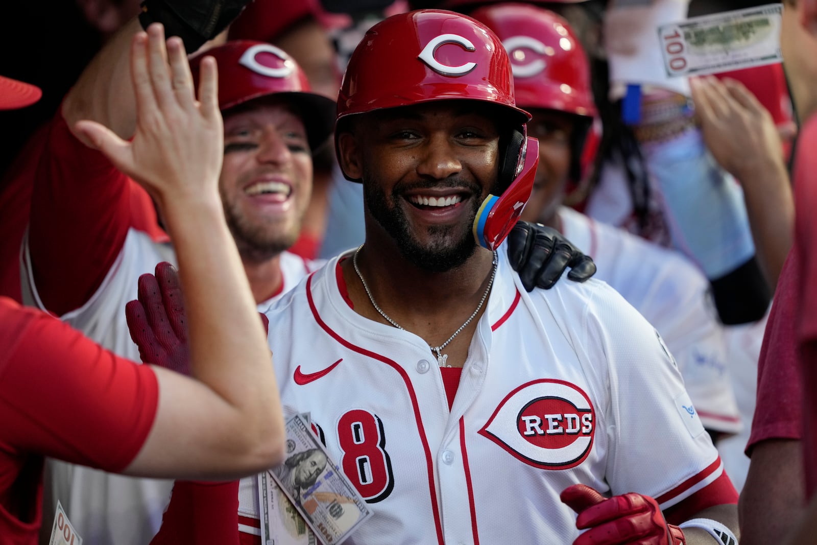 Cincinnati Reds' Miguel Andujar celebrates in the dugout after hitting a grand slam home run during the seventh inning of a baseball game against the Philadelphia Phillies Wednesday, Aug. 13, 2025, in Cincinnati. (AP Photo/Carolyn Kaster)
