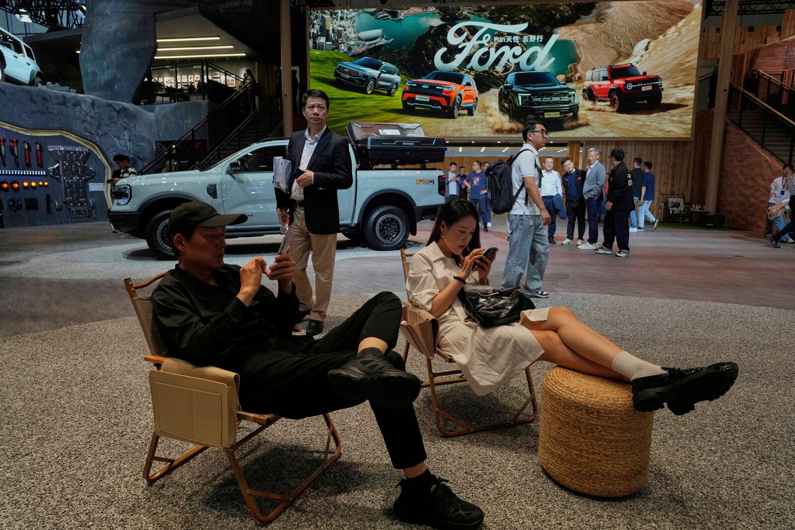 Visitors rest at the booth for US auto manufacturer Ford at the Shanghai auto show on Wednesday, April 23, 2025. (AP Photo/Ng Han Guan)