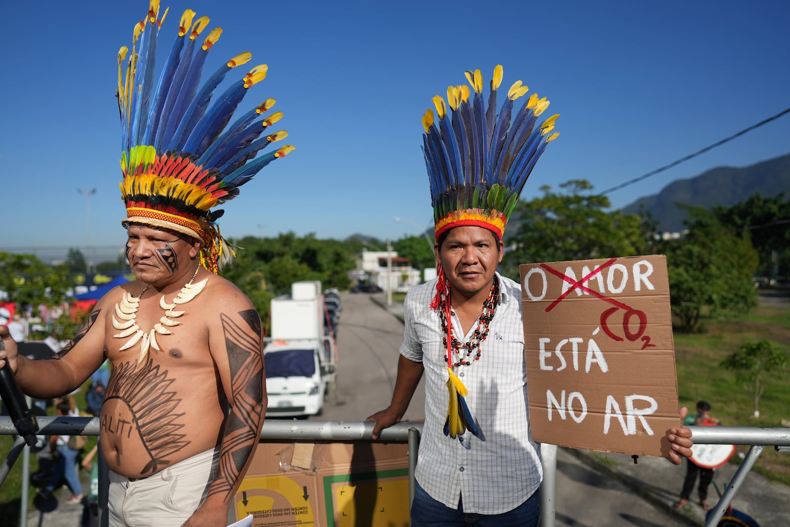 Indigenous demonstrators holds a sign that reads in Portuguese "Love, CO2 is in the air" to protest the auction of dozens of oil blocks, including blocks near the mouth of the Amazon River, in Rio de Janeiro, Tuesday, June 17, 2025. (AP Photo/Silvia Izquierdo)
