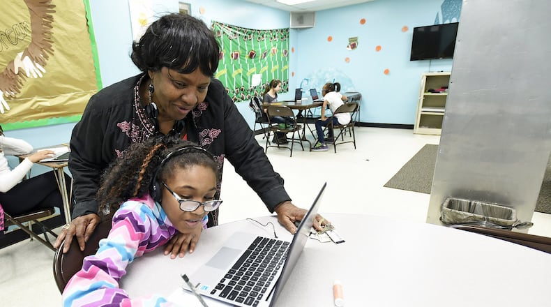Cecelia “Ceal” Thompson looks over over the shoulder of Tillana Hunter, 9, during an after-school program March 8 at the Robert “Sonny” Hill Jr. Community Center in Middletown. Thompson, who has been a part of the Middletown community center for 40 years, is being honored for her service later this month. NICK GRAHAM/STAFF