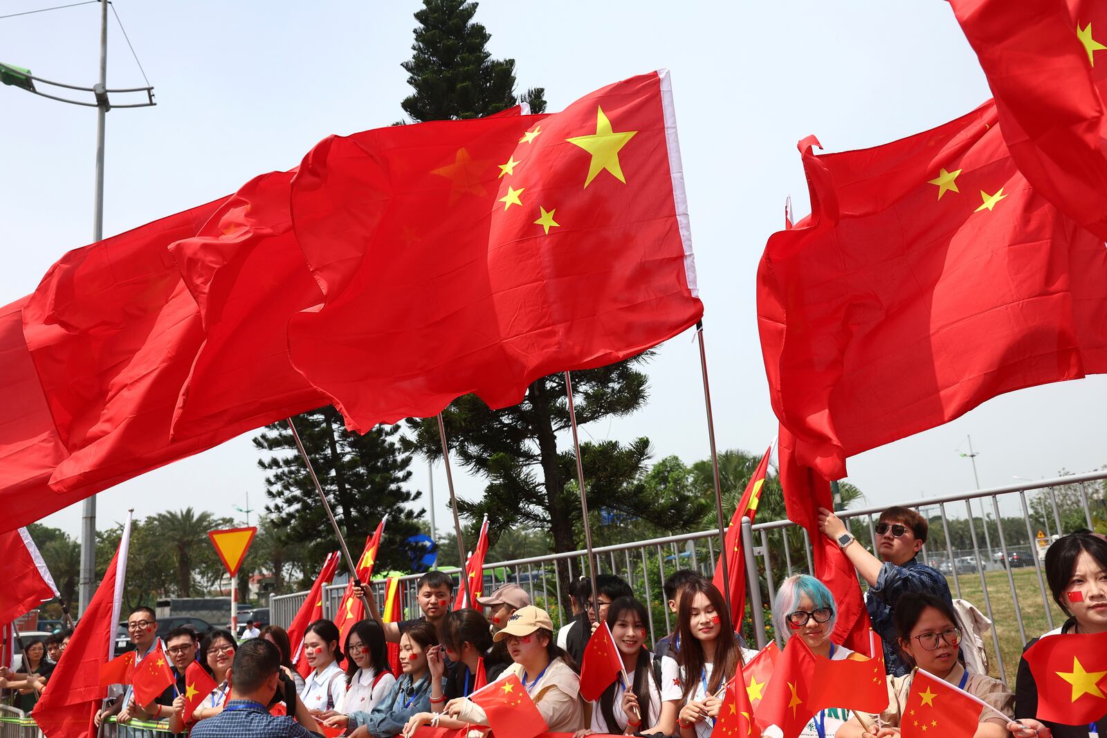 People wait for Chinese President Xi Jinping's arrival outside the Noi Bai International Airport in Hanoi, Vietnam Monday, April 14, 2025. (Athit Perawongmetha/Pool Photo via AP)