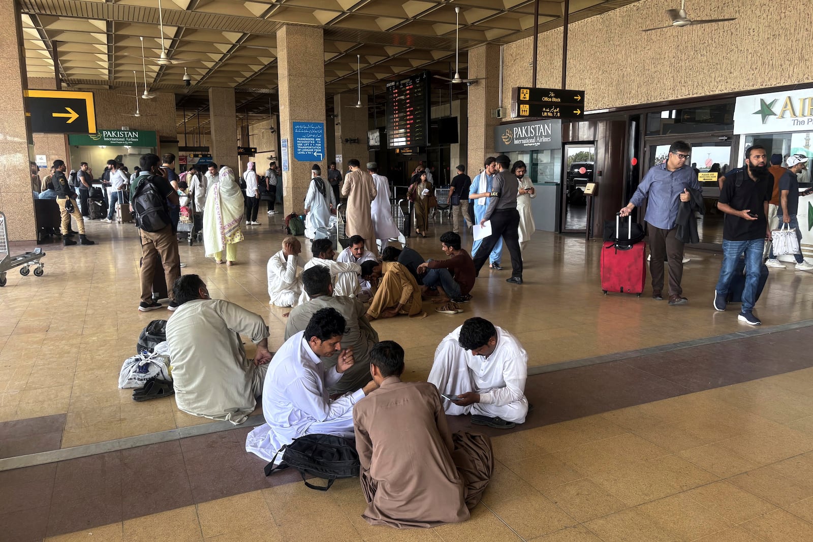 Stranded passengers wait at an arrival area of Jinnah airport after authorities closed the airport due to India's drone attack to Pakistan, in Karachi, Pakistan, Thursday, May 8, 2025. (AP Photo/Mohammad Farooq)