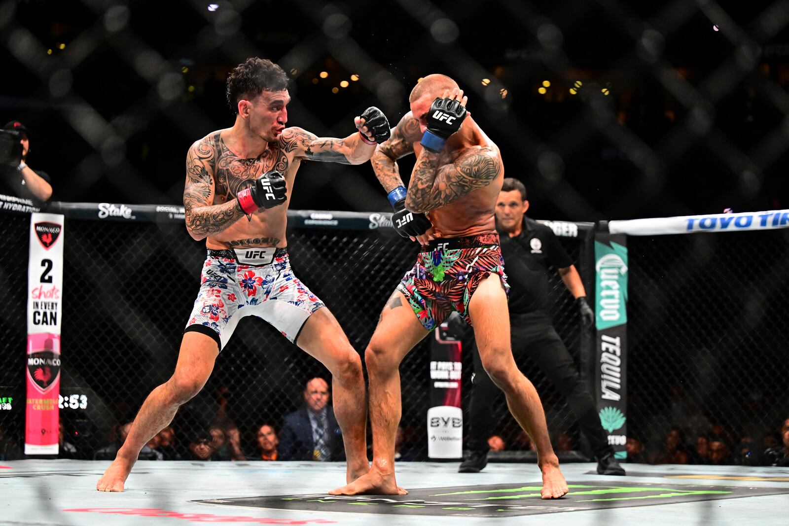 Max Holloway, left, hits Dustin Poirier in a lightweight title fight at UFC 318 in New Orleans, La., Saturday, July 19, 2025. (AP Photo/Ella Hall)