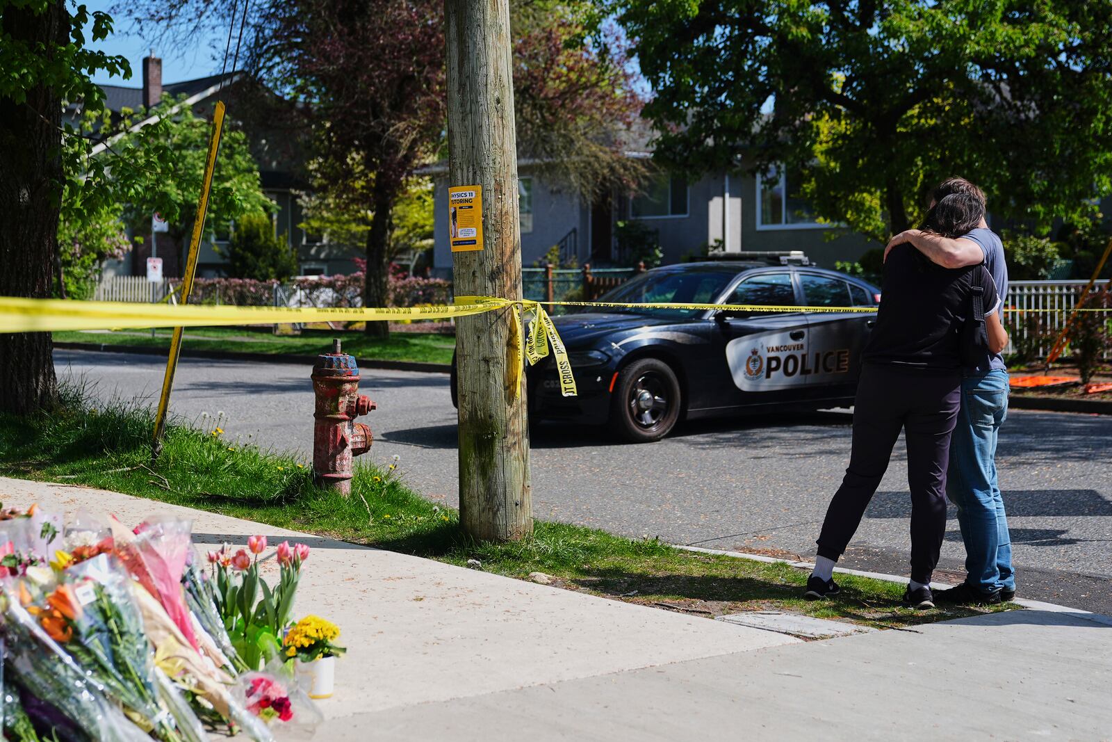 A couple hugs near the scene the day after a driver killed multiple people during a Filipino community festival Sunday, April 27, 2025, in Vancouver, British Columbia. (AP Photo/Lindsey Wasson)
